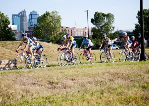 Cyclists biking in front of the KC skyline