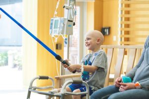 A young patient with a blue toy lightsaber at Children's Mercy Hospital