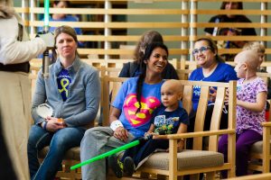 Young patients with toy lightsabers and family on benches at Children's Mercy Hospital