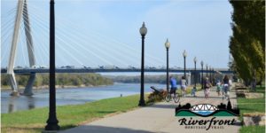 family biking down riverfront heritage trail